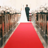 Rode loper voor een bruiloft in de kerk met bruidspaar