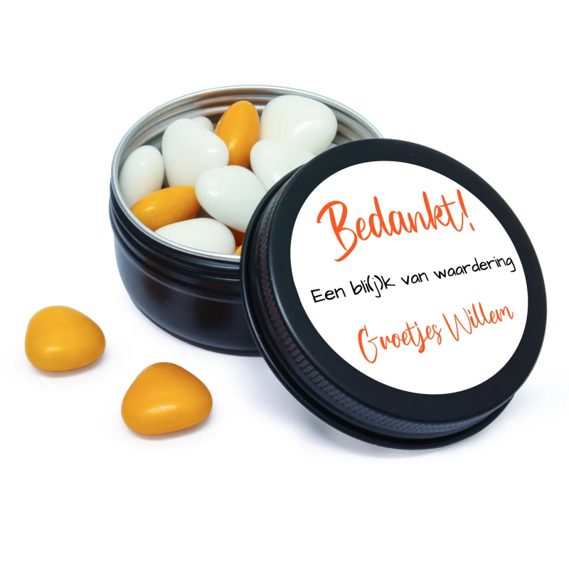 Zwart blikje van waardering met oranje snoepjes