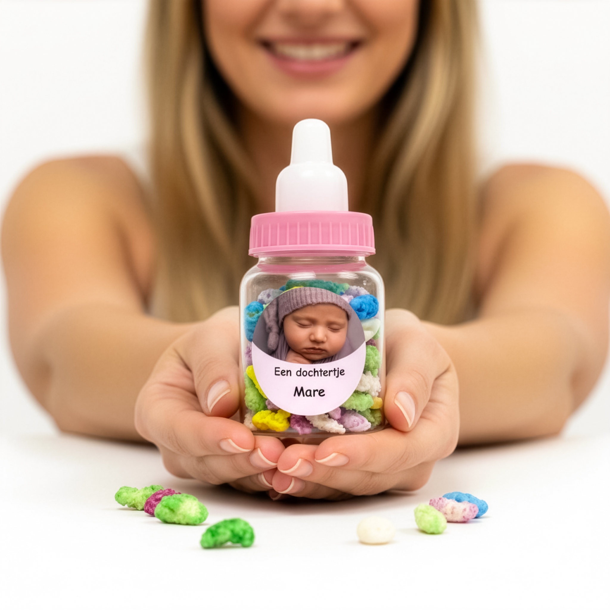 Papflesje met roze dop gevuld met manna voor geboorte in handen van vrouw