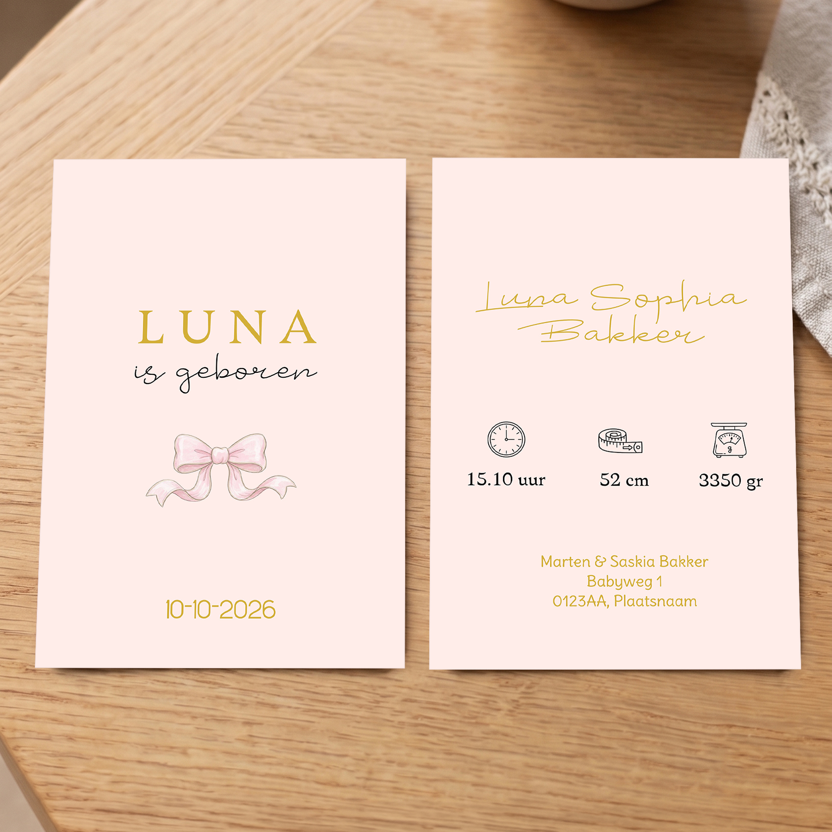 Geboortekaartje voor meisje met roze met strik - Voorkant en achterkant op tafel