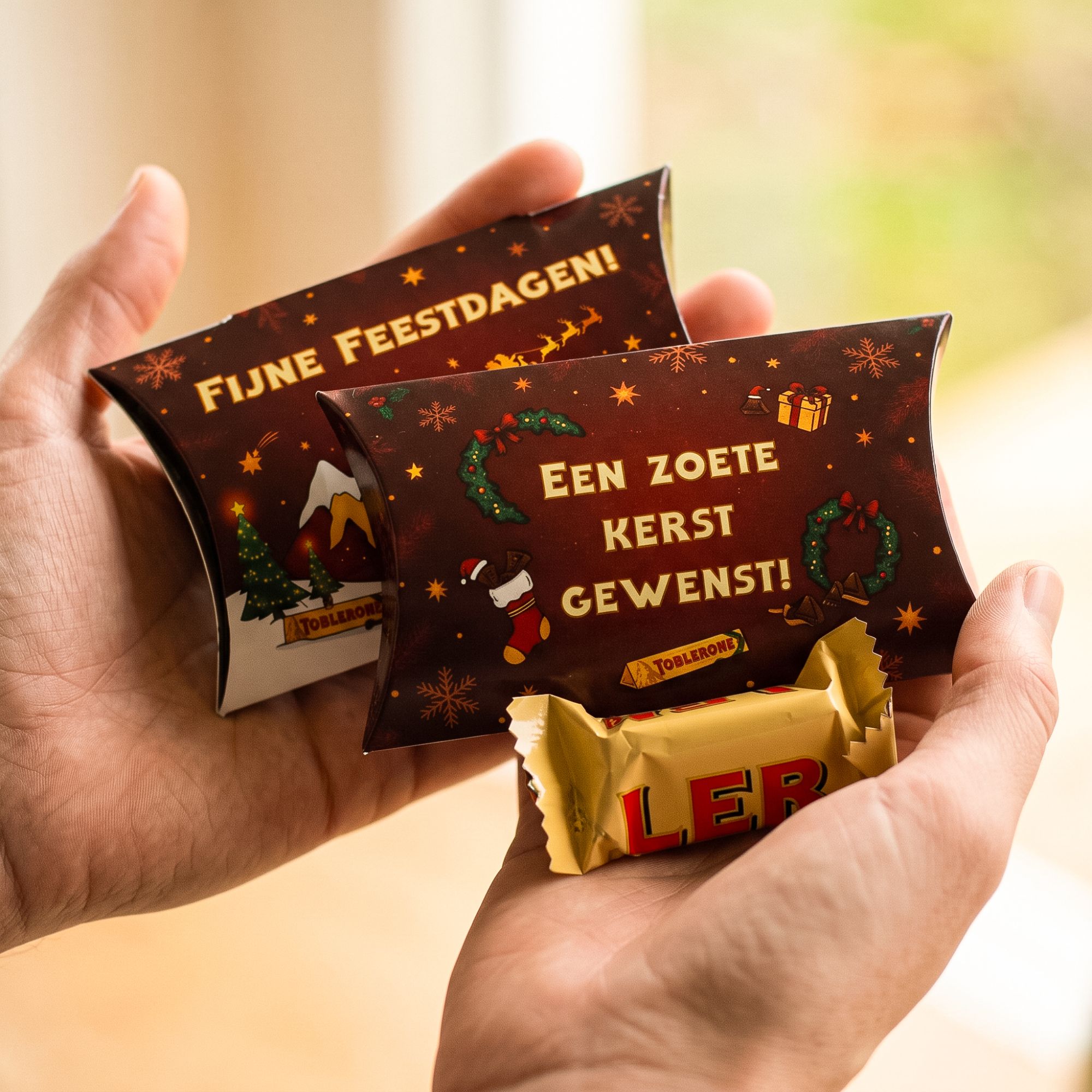 Kerst kussendoosje met mini Toblerone in handen